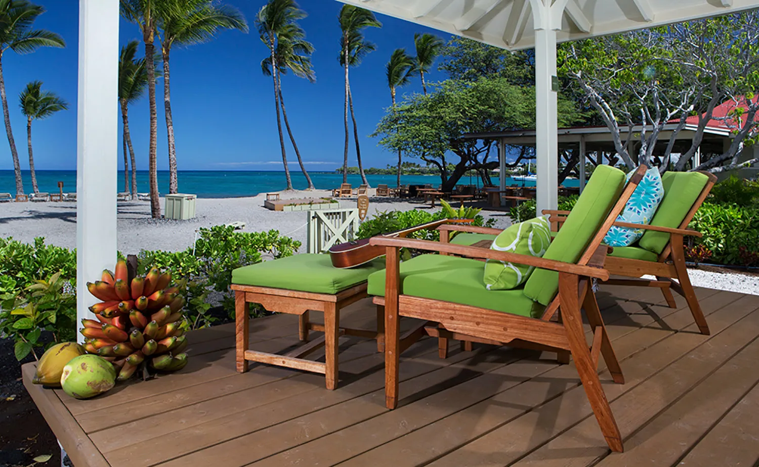 Colorful chairs on a Lava Lava cottage lanai overlooking the beach and palms